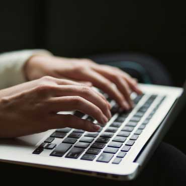 Person typing with laptop.