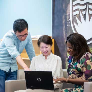 Three UBC staff members collaborating in the office.