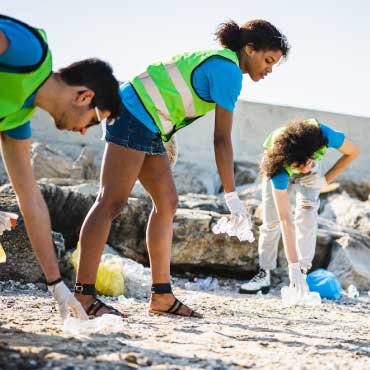 People picking up trash at a beach