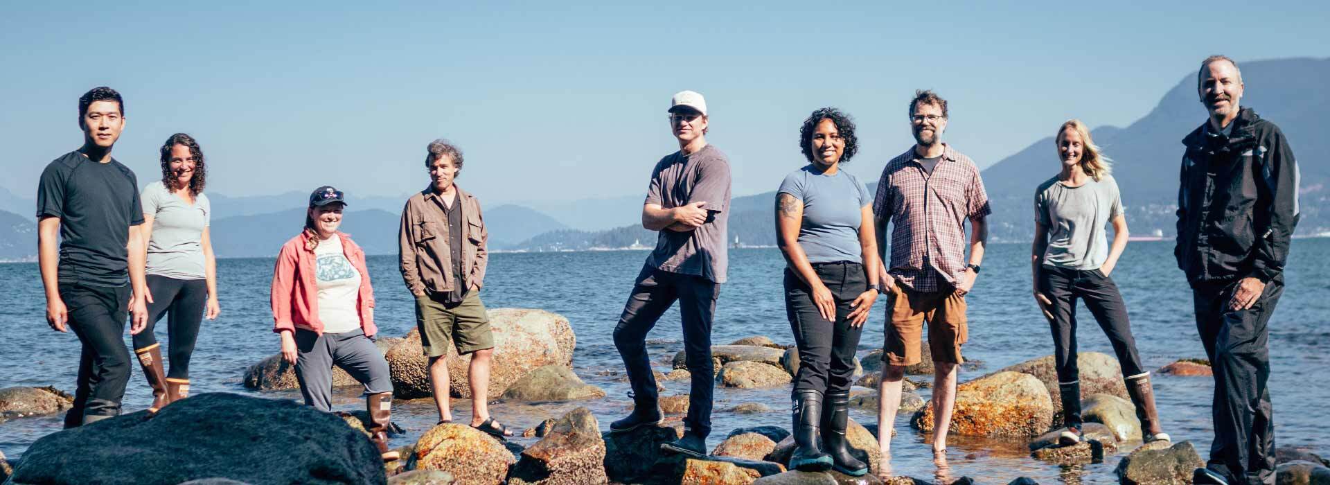 Researchers from UBC and the Hakai Institute standing on the shore.