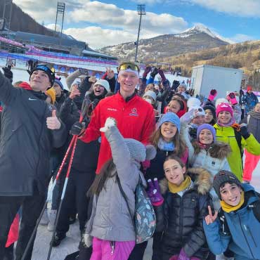 UBC Okanagan biathlon athlete Liam Simons poses with a group of Italian schoolkids after competing for Team Canada at the 2025 FISU World University Winter Games in Torino, Italy.