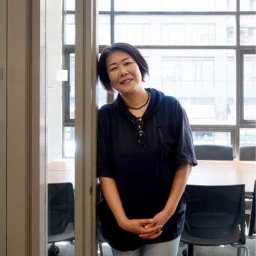 Yasuko Tamaki stands outside a UBC Learning Exchange meeting room where English Conversation Program sessions take place.