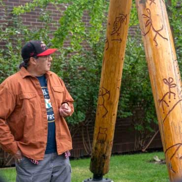 Syilx artist Les Louis standing outdoors at the UBC Okanagan campus